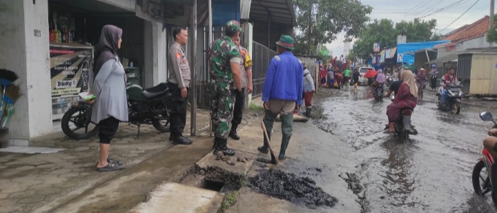 Personil Polsek Kedokan Bunder Ikut Membantu Atasi Genangan Air Yang Bisa Menyebabkan Laka Lantas
